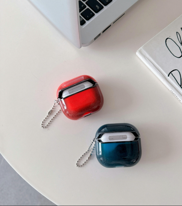 Coques AirPods translucides rouge et bleu sur un bureau